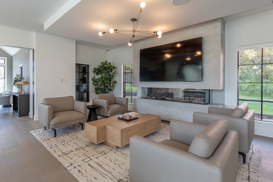 A modern living room with a large flat screen TV mounted on the wall.