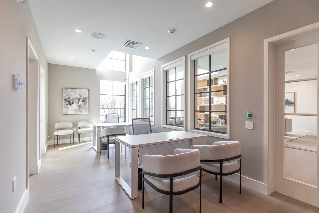 A well-lit room with a dining table and chairs.