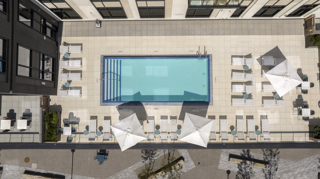 an aerial view of an office building with a pool and umbrellas