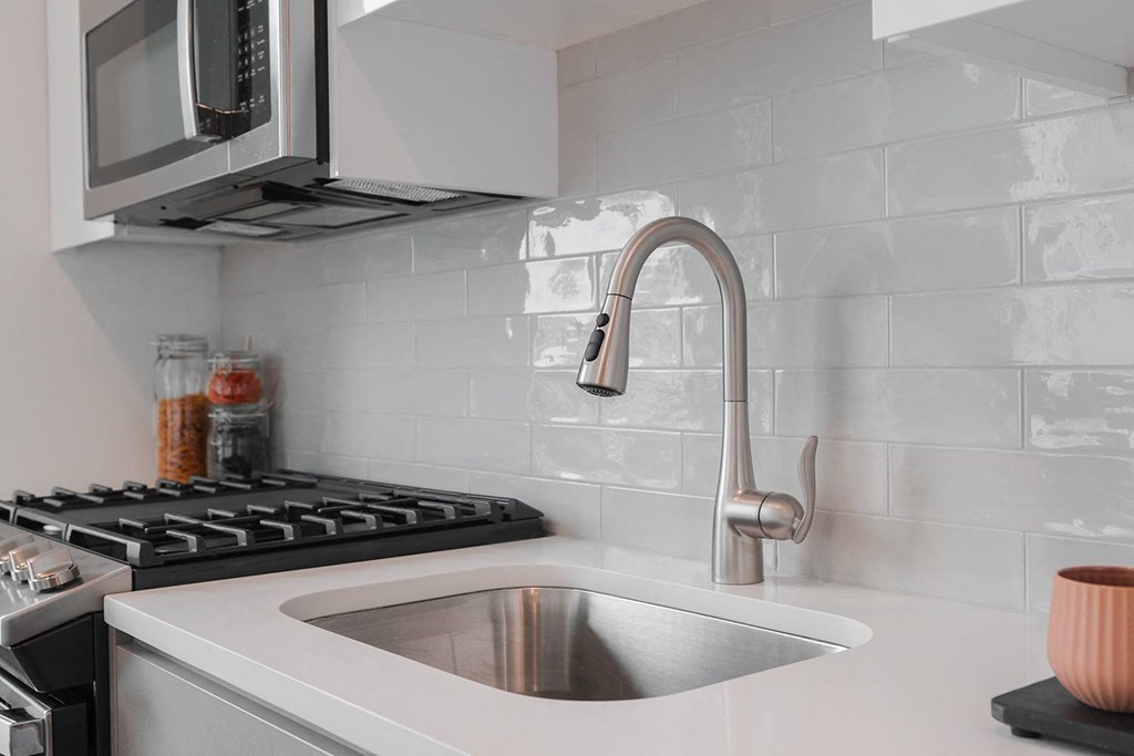 a kitchen with a sink and a microwave above it