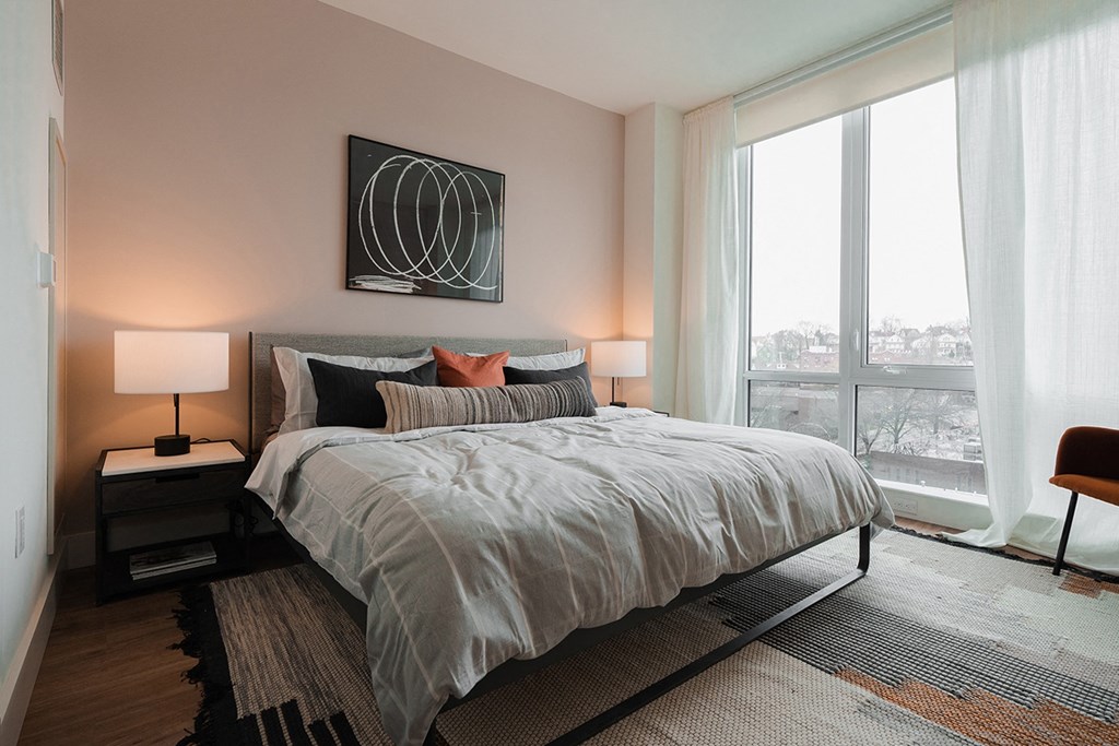 a bedroom with a bed and a large window