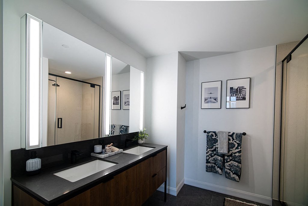 a modern bathroom with two sinks and a large mirror
