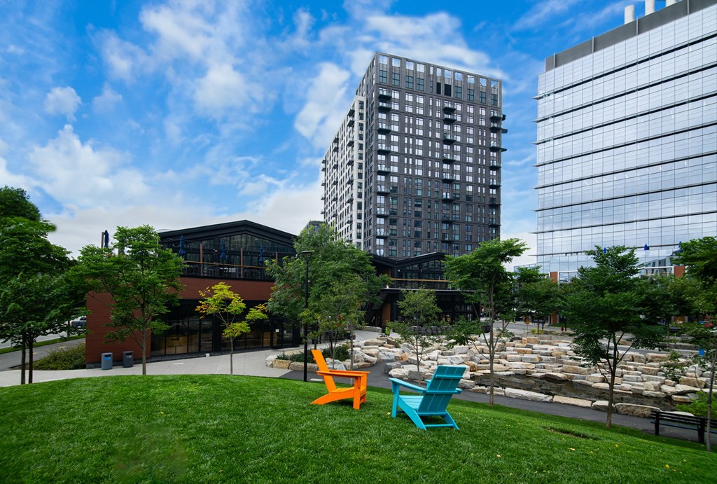 a park with colorful chairs in front of a tall building