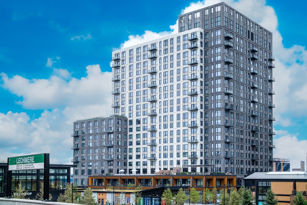 a tall apartment building with other tall buildings in the background