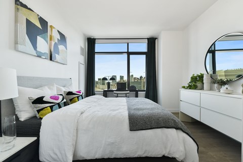 A bedroom with a large bed and a view of the city.