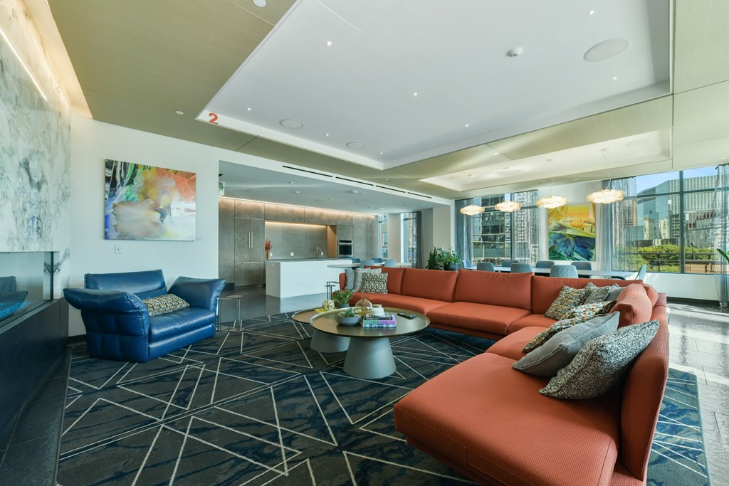 a living room with orange couches and blue chairs