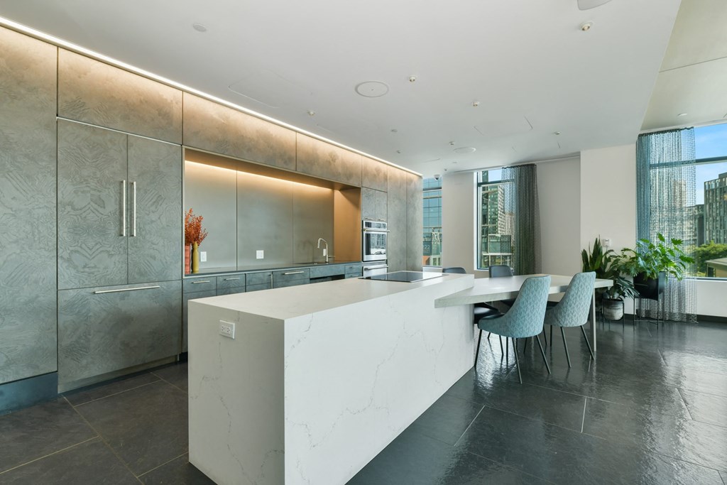 a kitchen with a large island and a table with chairs