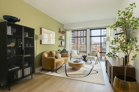A living room with a yellow chair and a large window.