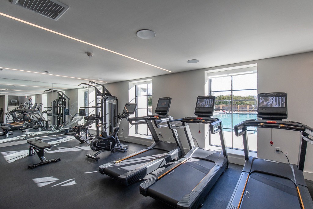 A gym with treadmills, exercise bikes, and other equipment.