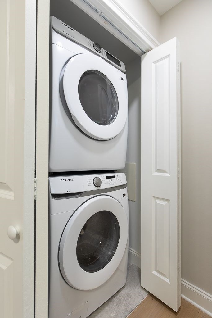 A white door is open to a small laundry room with a washer and dryer.