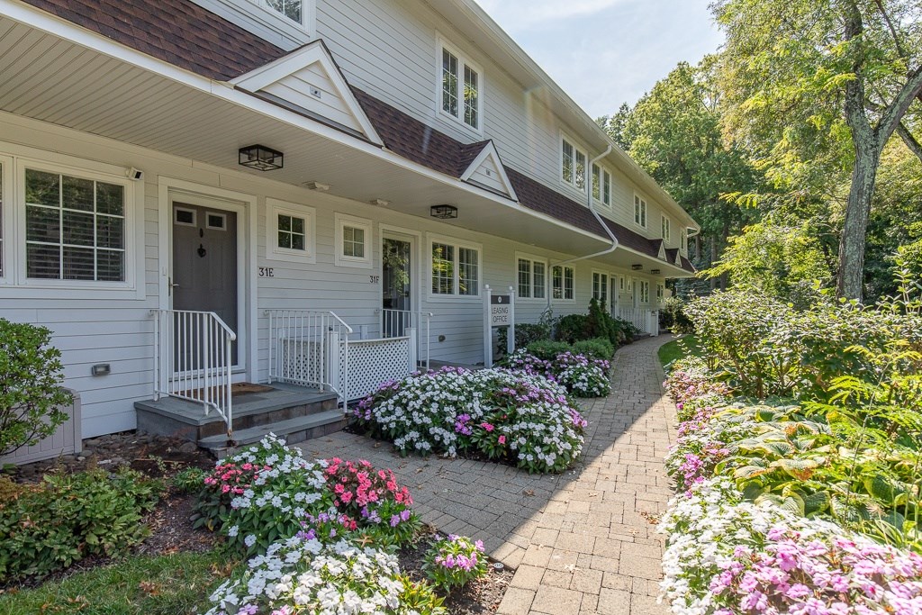 A white house with a brown roof and a front porch.