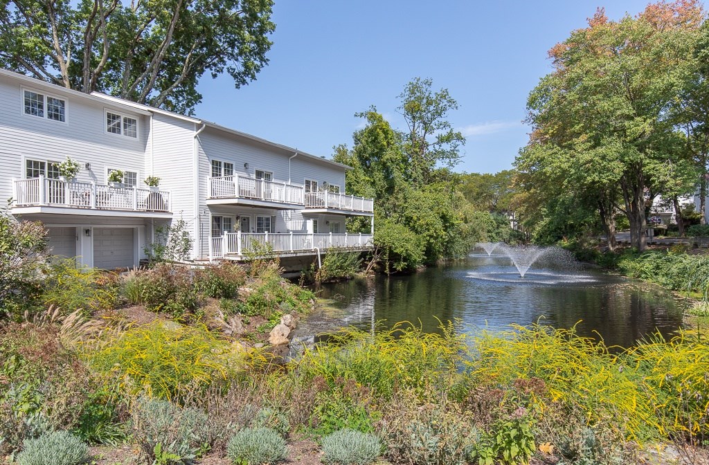 A white building with a fountain in front of it.