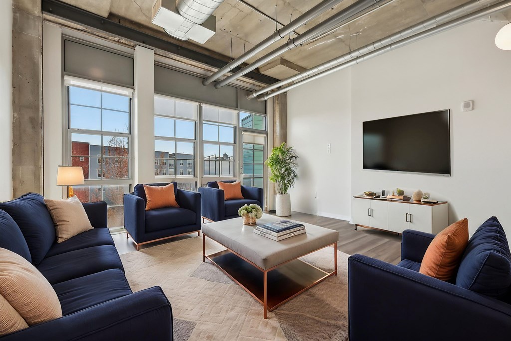 A living room with blue couches and a large window.