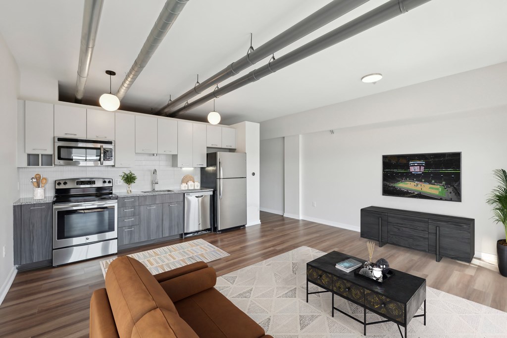 A modern kitchen with a brown sofa and a coffee table.