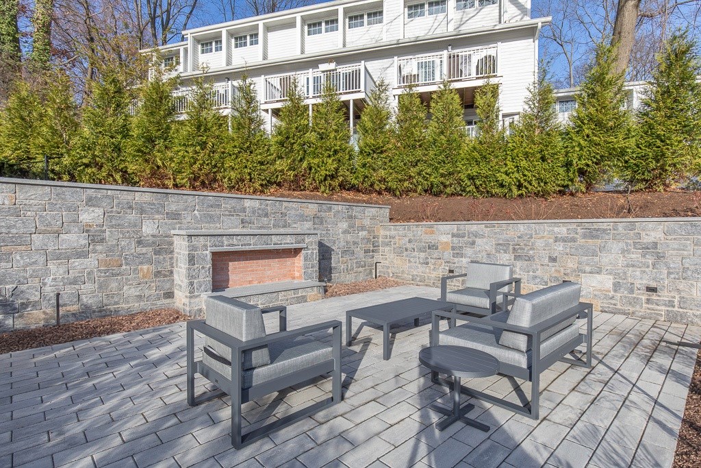 A patio with a table and chairs and a fireplace.