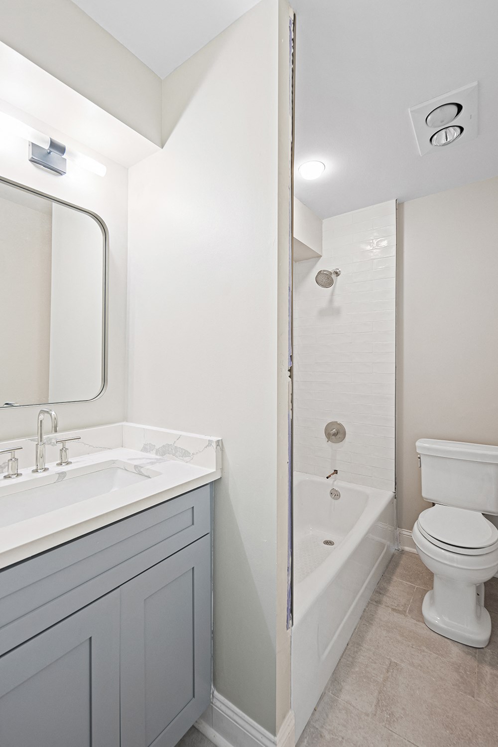 Newly renovated bathroom with new cabinetry, new finishes, new bath flooring and