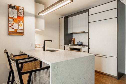 a kitchen with white cabinets and a marble counter top
