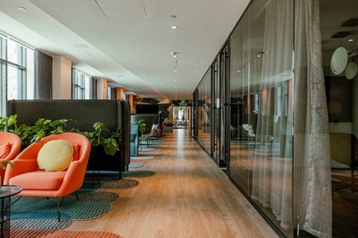 a long corridor with chairs and windows in a hotel lobby