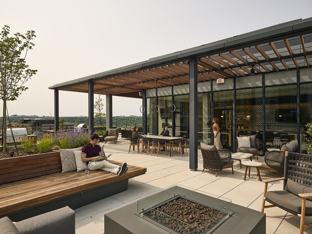 a man sitting on a bench in front of a fire pit on a patio
