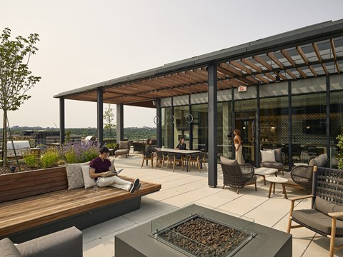 a man sitting on a bench in front of a fire pit on a patio