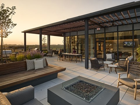 an outdoor patio with a firepit and wooden furniture