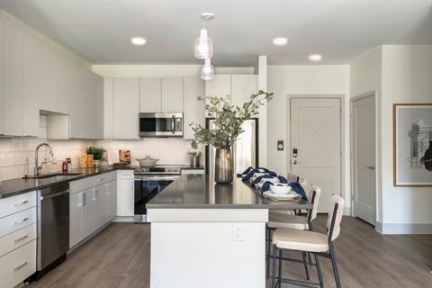 a kitchen and dining room with white cabinets and stainless steel appliances