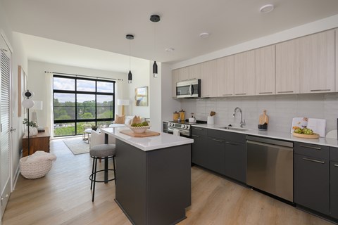 A modern kitchen with a large island and stainless steel appliances.