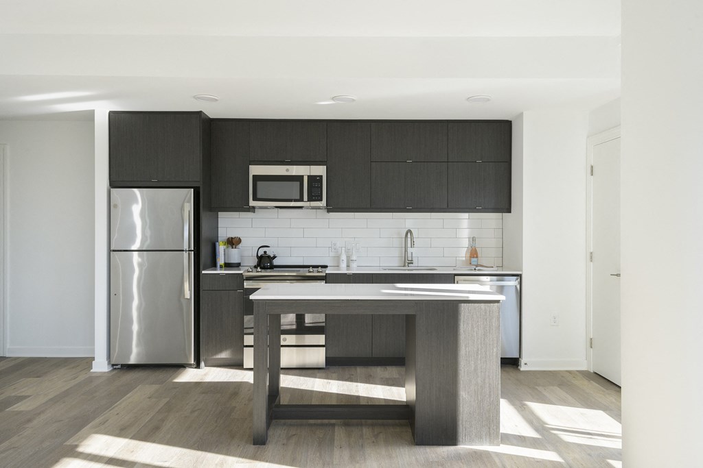 a kitchen with a large island and stainless steel appliances