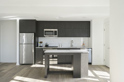 a kitchen with a large island and stainless steel appliances