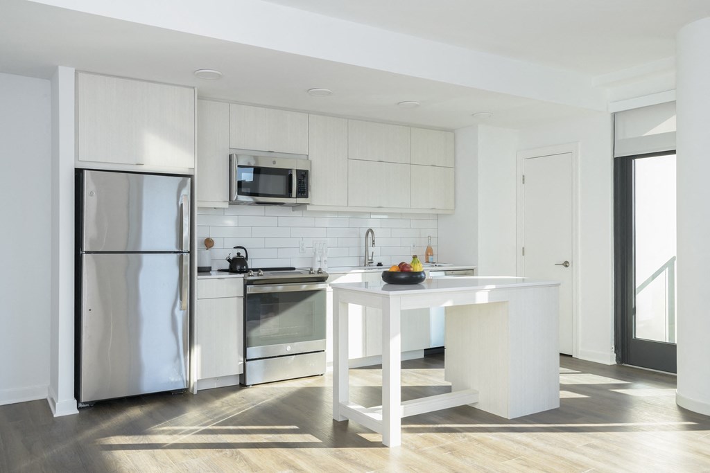 a kitchen with white cabinets and stainless steel appliances