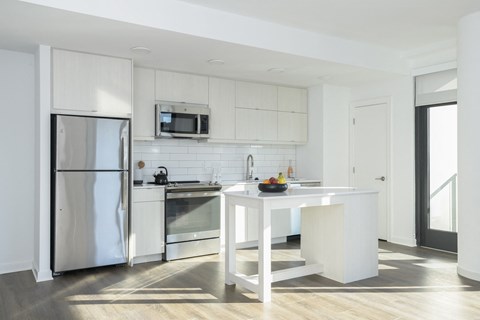 a kitchen with white cabinets and stainless steel appliances