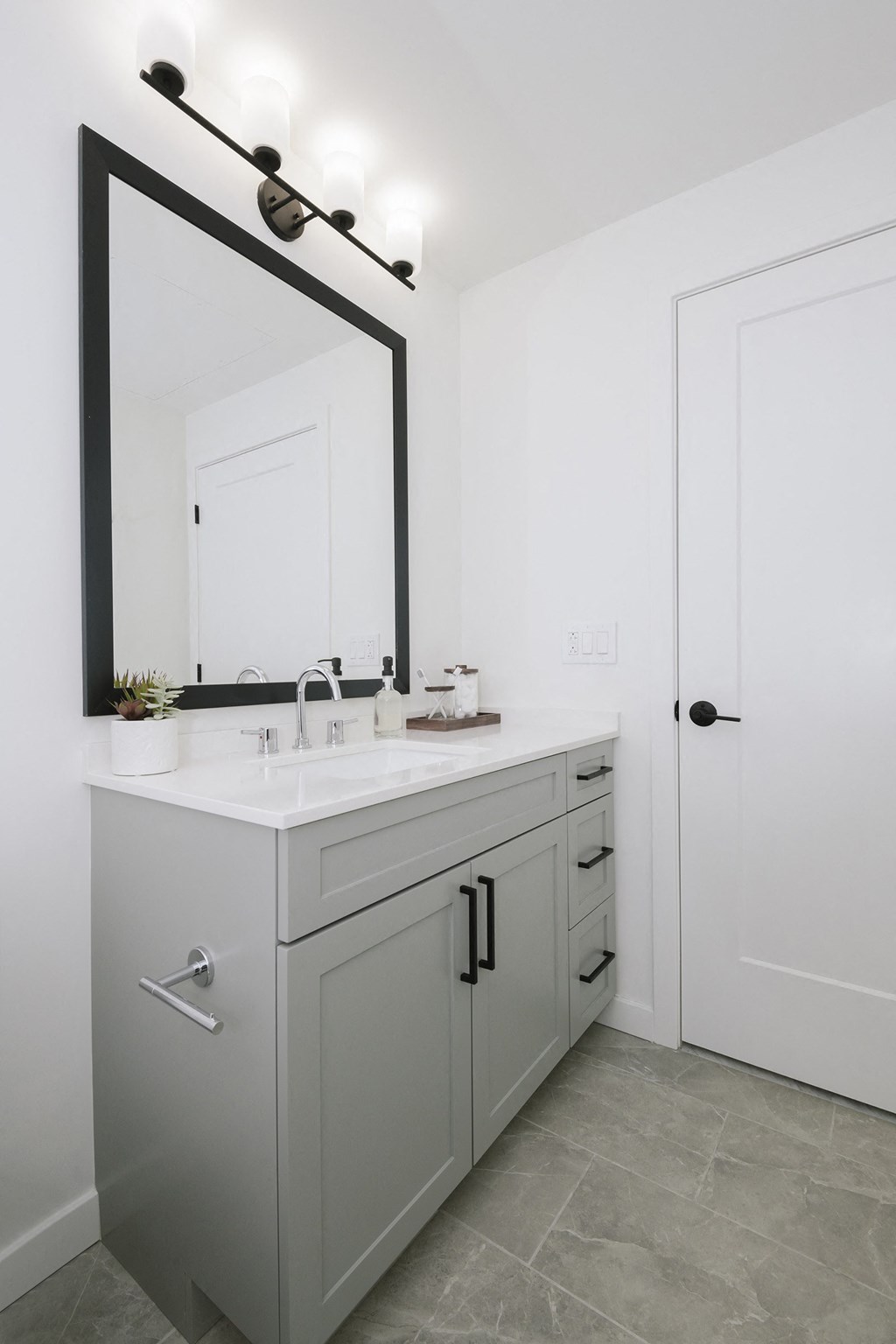 a white bathroom with a white sink and a mirror
