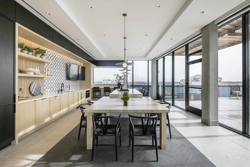 a large dining room with a table and chairs and a wall of windows
