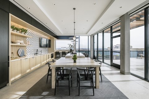 a large dining room with a table and chairs and a wall of windows
