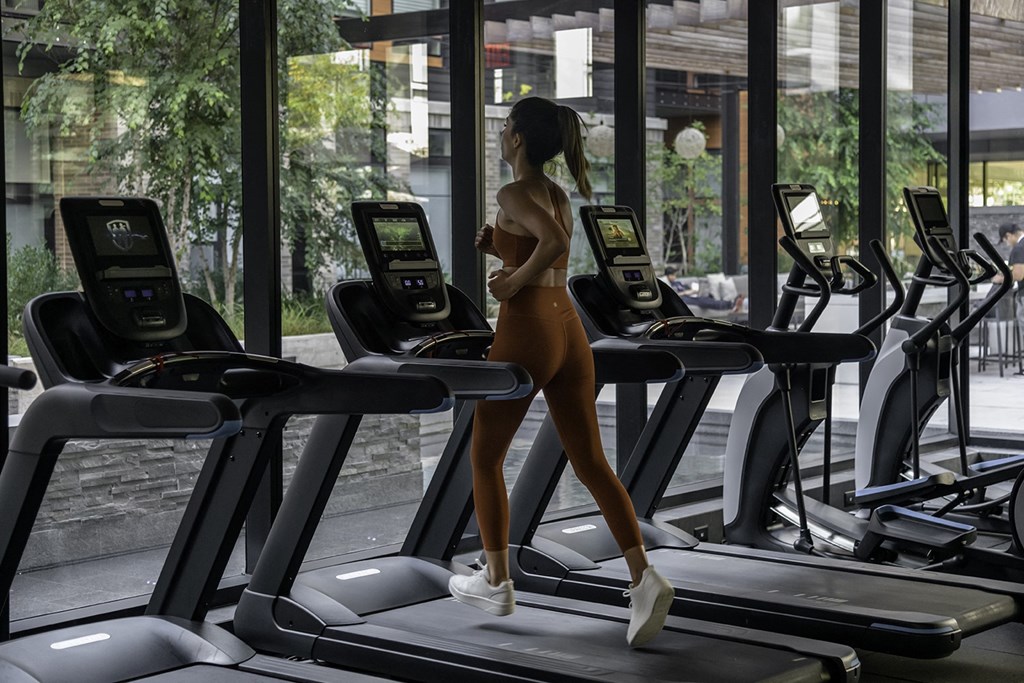 a woman walking on a treadmill in a gym at Arrowwood Apartments, North Bethesda