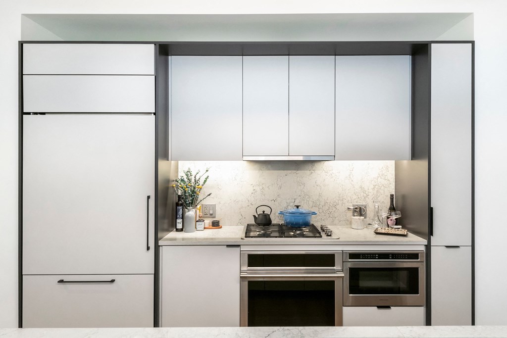 a white kitchen with white cabinets and stainless steel appliances