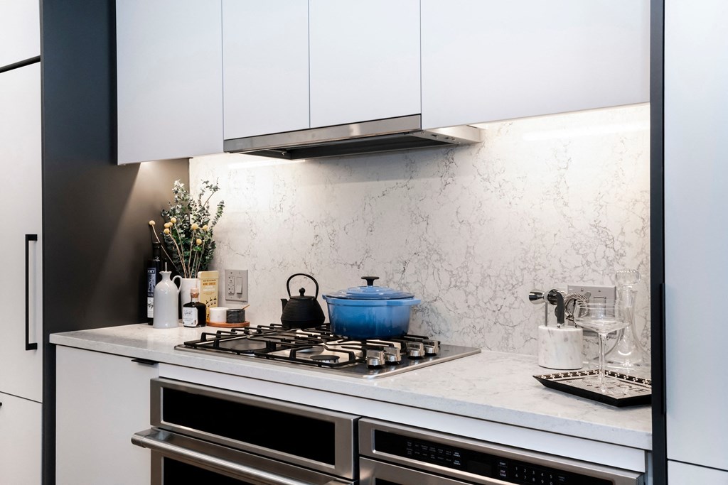 a kitchen with white cabinets and a stove top