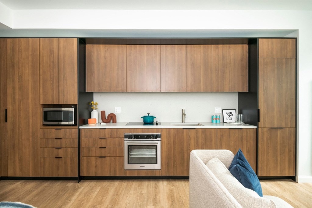 a kitchen with wooden cabinets and a sink and a microwave