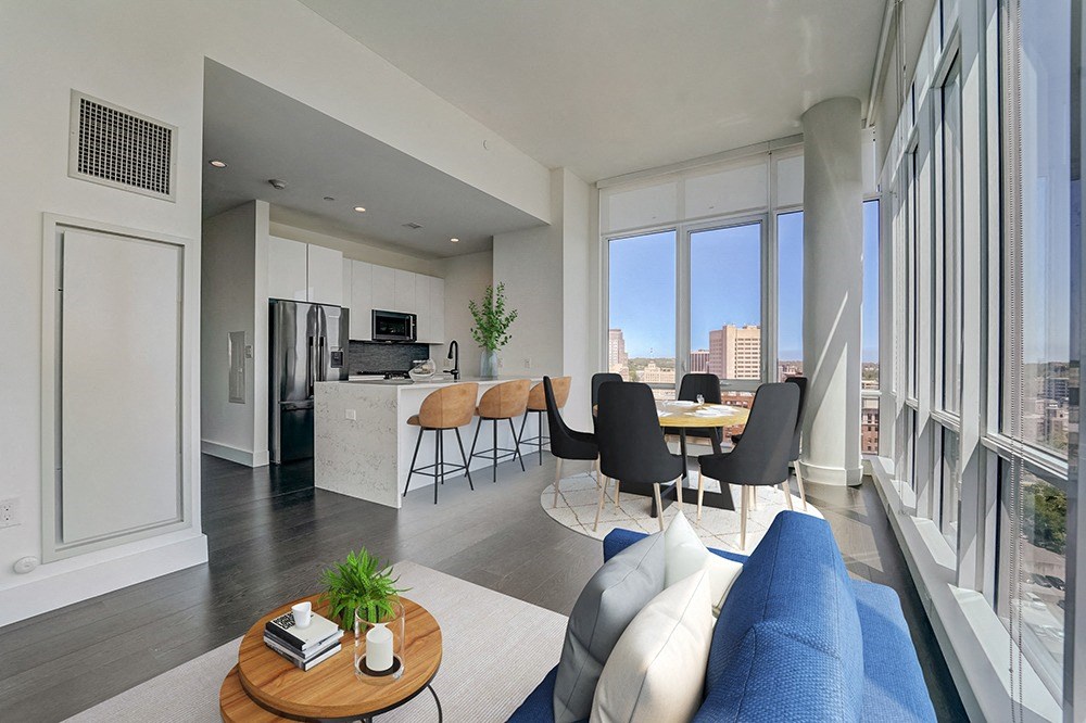 penthouse open living room and kitchen area with a large window and a view of the city at Continuum, New York