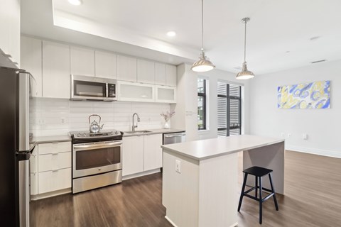 A modern kitchen with white cabinets and a large island.