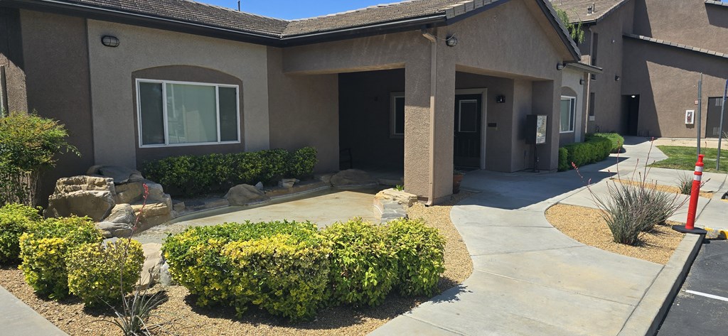 a building with a sidewalk and landscaping in front of it