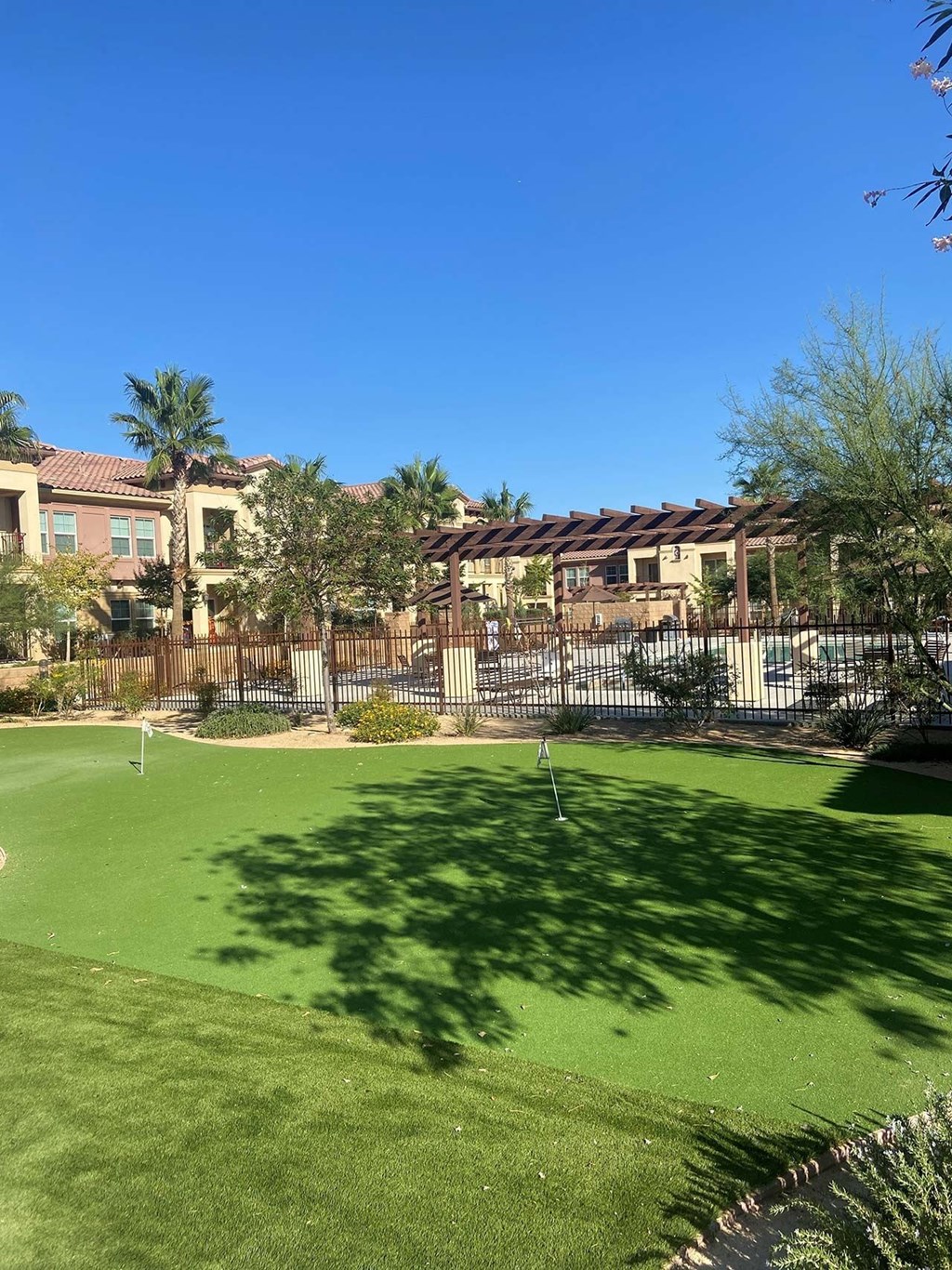 A green lawn in front of a building. A green lawn in front of a building.at The Villas 55+ II Hesperia, California
