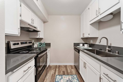A kitchen with a stove top oven and a sink.