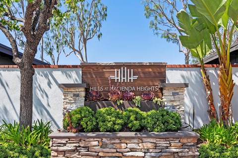 A sign that says "Hills at Hacienda Heights" is displayed in front of a building.