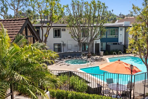 A pool surrounded by trees and a house in the background.at Hills at Hacienda Heights, Hacienda Heights, 91745