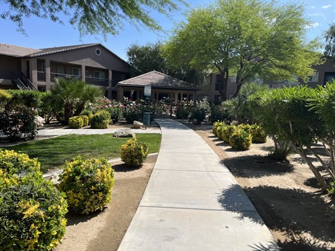 a sidewalk in a garden in front of a building