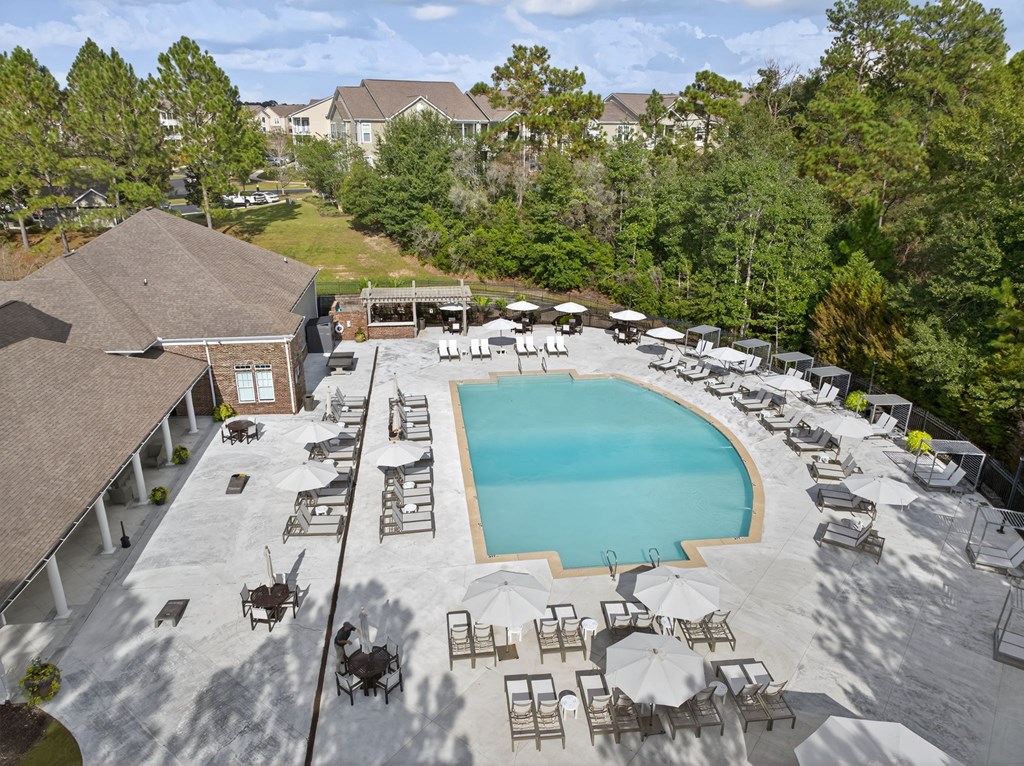 An aerial view of a pool surrounded by lounge chairs and umbrellas.