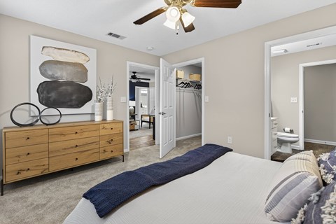 A bedroom with a large bed and a wooden dresser.