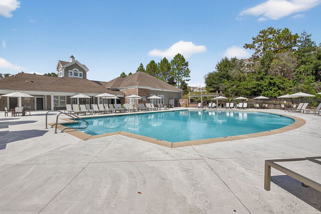 A large outdoor swimming pool with a building in the background.