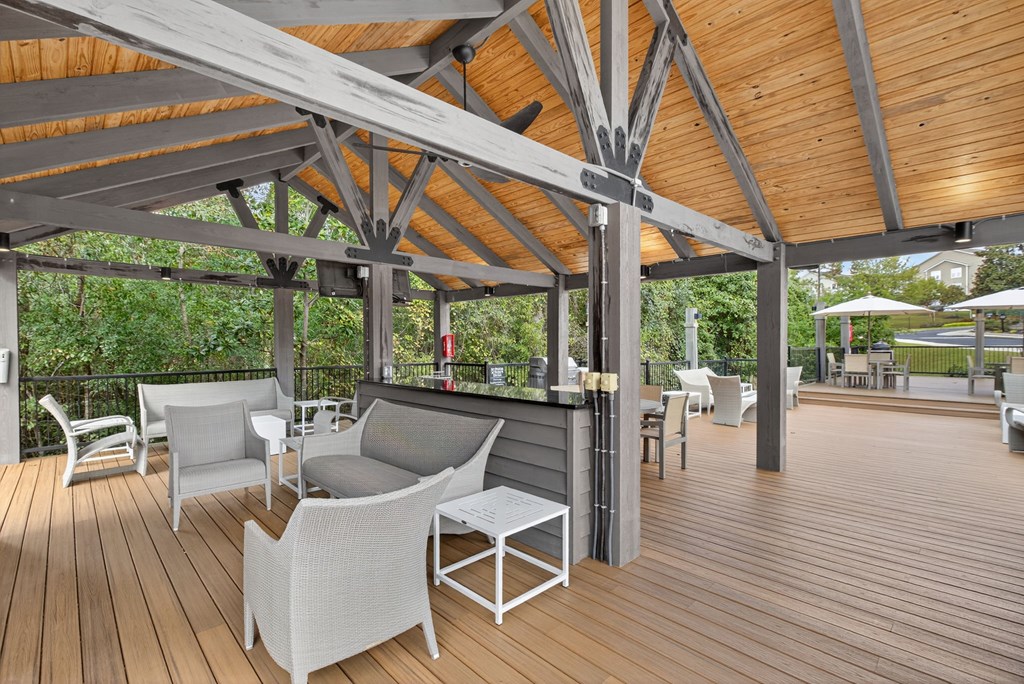 A wooden deck with white chairs and a table.